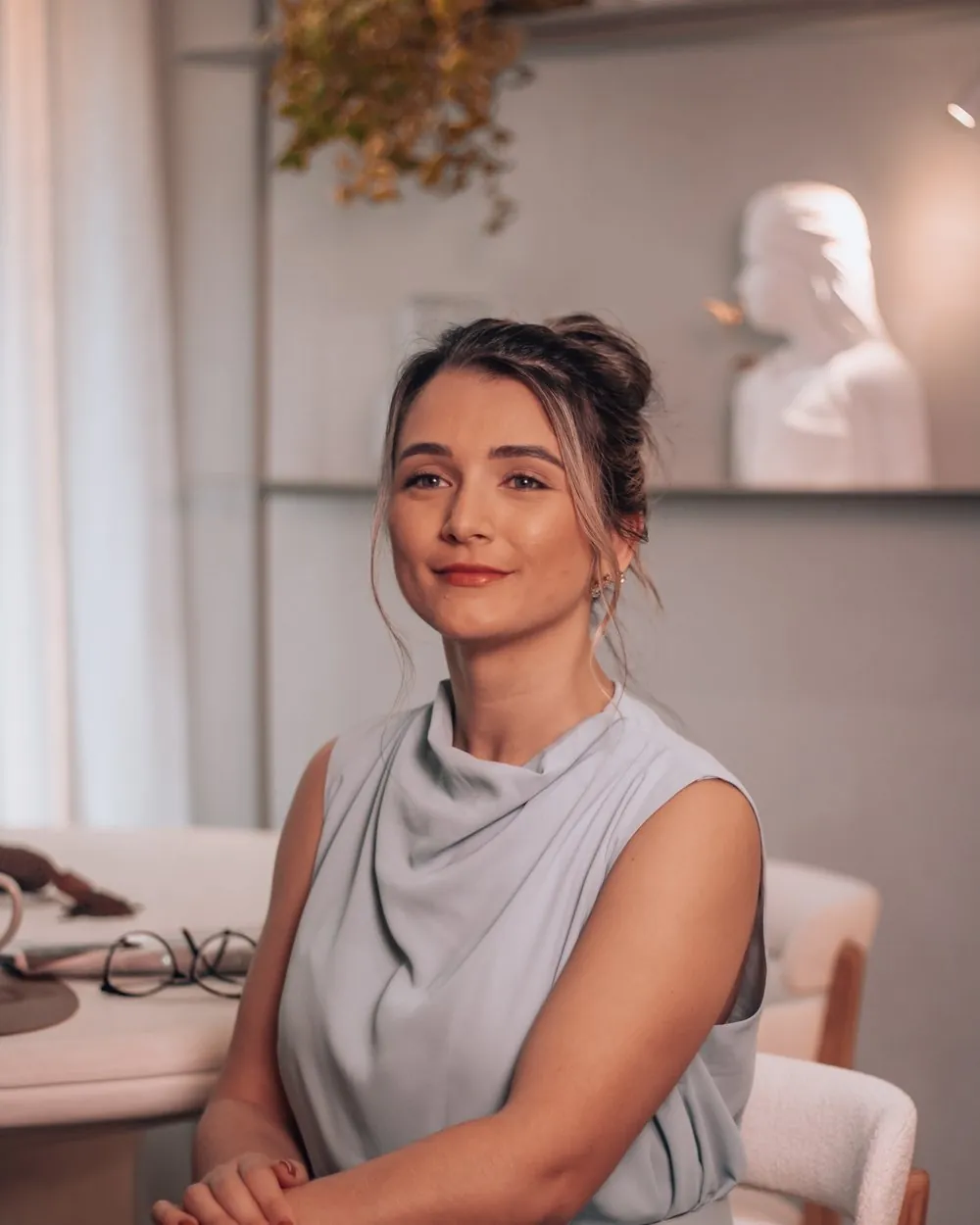Retrato de Sabrina Ferreira, arquiteta de interiores, sentada no escritório